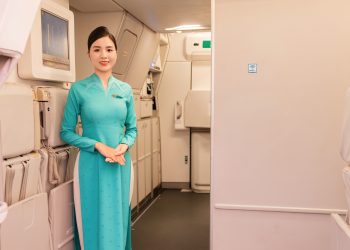 Tiếp viên Vietnam Airlines đứng chào đón hành khách ở cửa máy bay