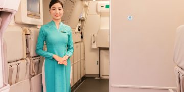 Tiếp viên Vietnam Airlines đứng chào đón hành khách ở cửa máy bay